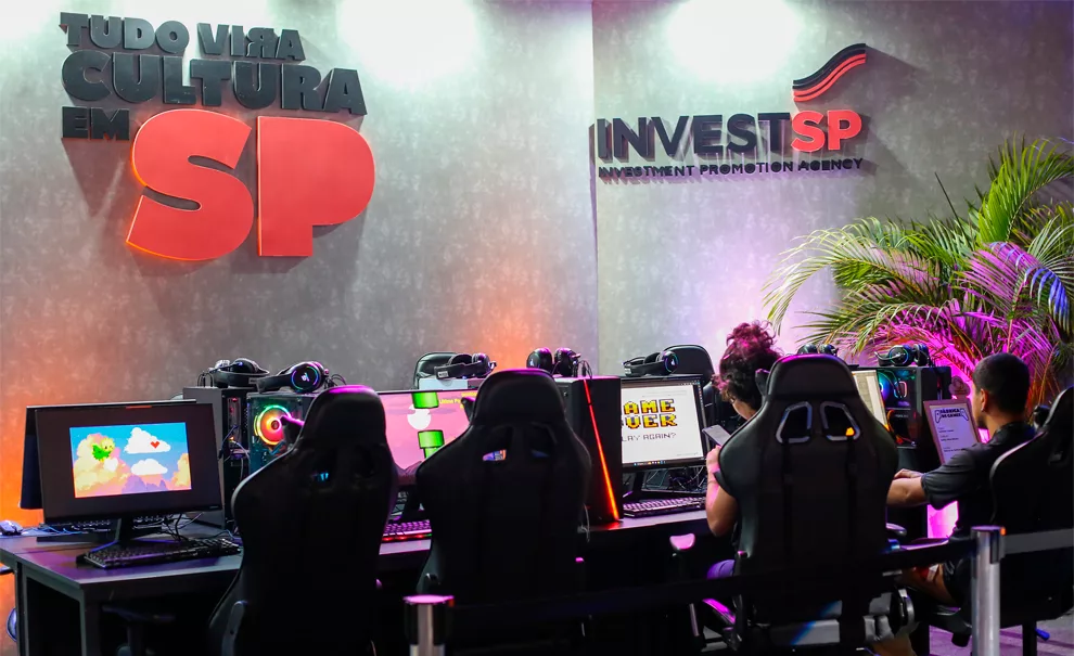 Sala com computadores e a frase "tudo vira cultura em SP" na parede. Secretaria de Cultura de São Paulo investindo em pop e games.